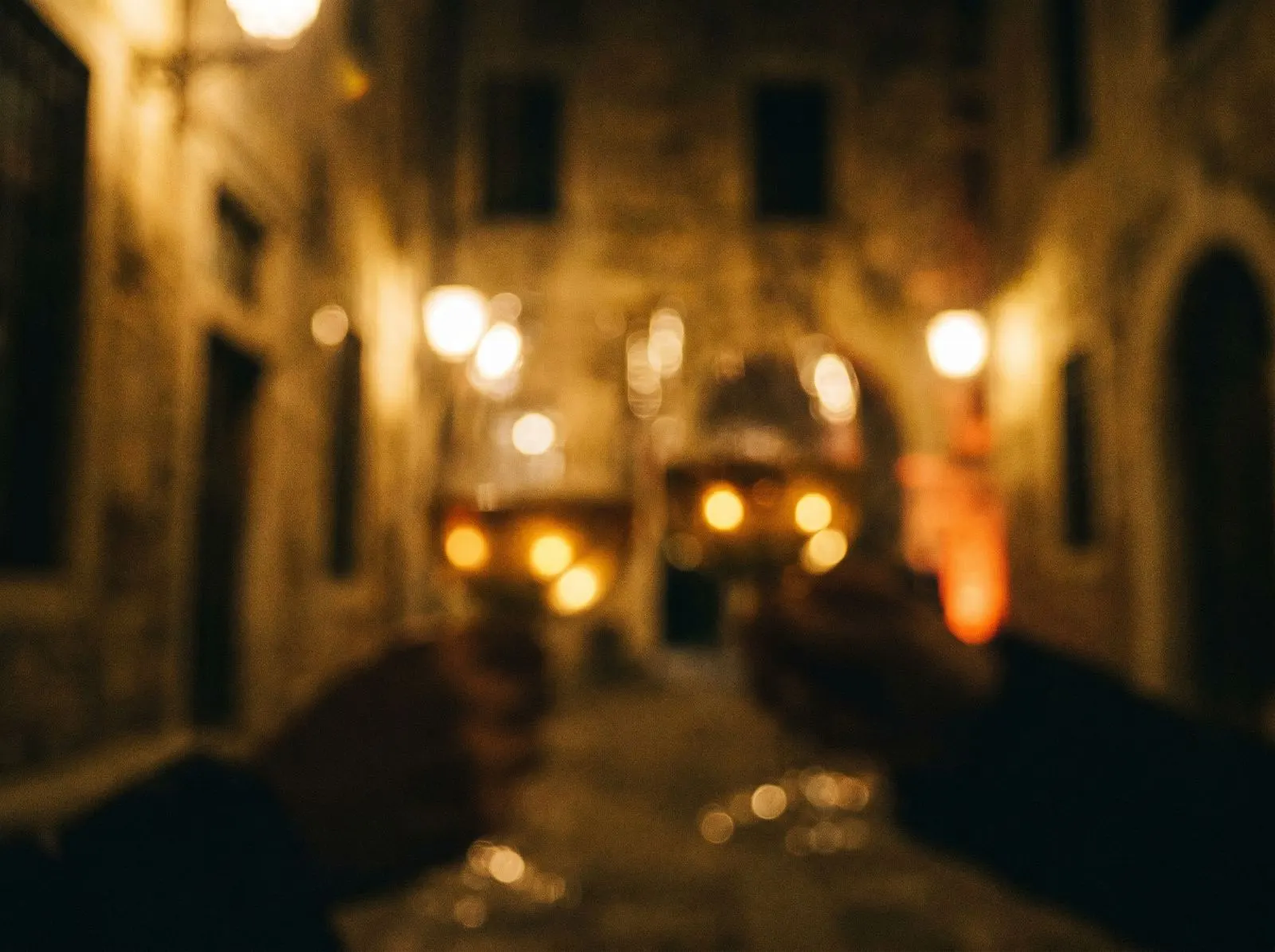 Warm bokeh and wine glasses, dim restaurant